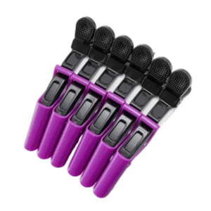 Purple hair clips with black ends on a light gray surface
